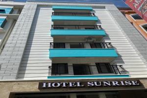 a hotel sunrise sign in front of a building at Hotel Sunrise in Kanyakumari
