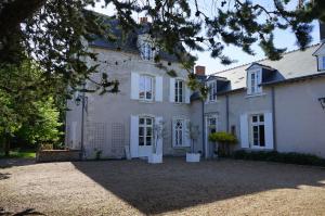 a large white house with a large yard at Le Clos des Péziers in Vineuil