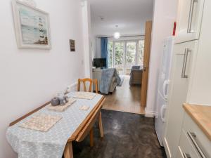 a kitchen and dining room with a table and a refrigerator at 10 The Orchard in Colwyn Bay