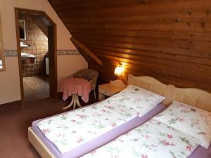 um quarto com uma cama e uma cadeira num sótão em Gästehaus "Gisela" im fürstlichen Fischhaus em Schillingsfürst