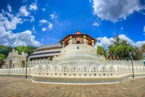 un gran edificio blanco con un cielo azul en el fondo en Kandy Dawson Bungalow en Kadugannawa