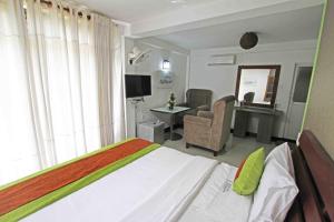 a bedroom with a bed with a desk and a chair at Kandy Dawson Bungalow in Kadugannawa