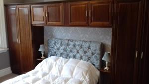 a bedroom with a bed and wooden cabinets at Lansdown House Bed & Breakfast in Market Drayton +8 photos