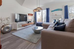 een woonkamer met een bank en een tv bij Ferienwohnung Waldloft in Ostseebad Sellin