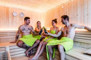 um grupo de quatro pessoas sentadas numa sauna em Alpenhotel Tyrol - Konzepthotel - adults only em Pertisau
