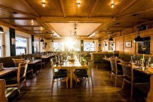 una sala da pranzo con tavoli e sedie in legno di ALPENHOTEL TYROL - B&B - Hundefreundliches Konzepthotel - adults only a Pertisau
