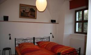 MüglitztalにあるFerienwohnung-im-Pfarrhausのベッドルーム1室(オレンジ色の枕が付いたベッド1台付)