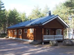 a small wooden house with a porch in the woods at Rönnäs Seaside Resort in Isnäs