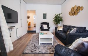 uma sala de estar com um sofá e uma mesa em Luxurious two bedroom apartment A kwartier Center em Groningen