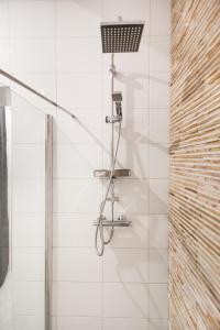 a shower in a white tiled bathroom with at Luxurious two bedroom apartment A kwartier Center in Groningen