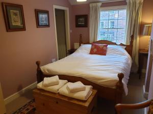 a bedroom with a bed with white sheets and a window at 7 Monk Bar Court YORK in York