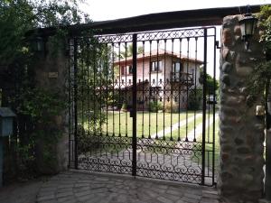 een ijzeren poort met een huis op de achtergrond bij Residencia en Casa de artista in Vistalba