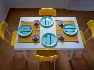 einen Tisch und Stühle mit Tellern und Geschirr darauf in der Unterkunft Leisure Moments Maisonette by TravelPro Services Possidi Halkidiki in Posidi
