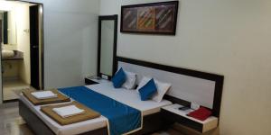 1 dormitorio con 1 cama con almohadas azules y blancas en SEA WINDS en Ratnāgiri