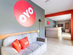 uma sala de estar com um sofá e um sinal na parede em OYO Hotel Recanto Do Alto, Teresópolis em Teresópolis