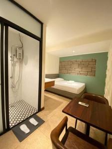 a room with a shower and a table and a bedroom at The Hub District Garden Suites in Manila +39 photos
