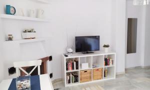 salon z telewizorem na białej półce w obiekcie holidays in pueblo evita w mieście Benalmádena