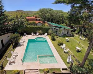an overhead view of a swimming pool with chairs and a house at Bad-wiessee Apart Hotel & Spa in Villa General Belgrano