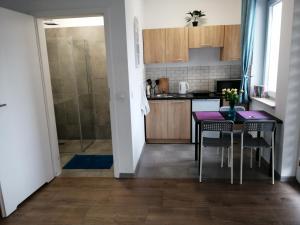 a kitchen with a table and a refrigerator at POKOJE - STUDIO GLIWICE in Gliwice