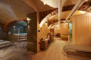 a large room with wooden floors and a room with a tub at Hiša Ančka, Boutique Hotel & Maja Rooms in Slovenj Gradec