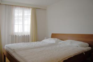 Schlafzimmer mit einem weißen Bett und einem Fenster in der Unterkunft Chalet Obelix in Grindelwald