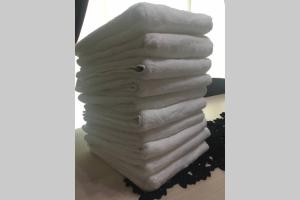 a stack of white towels sitting on a table at Pasir Gudang Marissa Homestay in Masai +40 photos