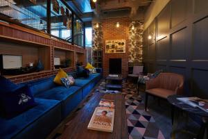 a living room with a blue couch and a table at voco Manchester - City Centre, an IHG Hotel in Manchester