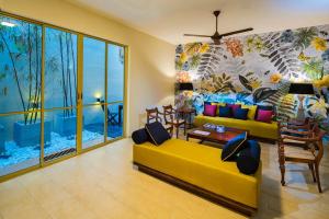 a living room with a yellow couch and a colorful mural at Rosmead Place by Thilanka in Colombo