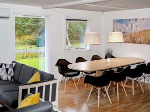 a living room with a table and chairs at 8 person holiday home in R dby in Kramnitse