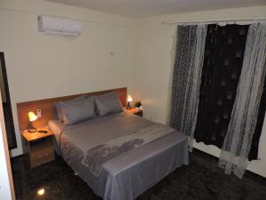 una camera con un letto e una finestra con due lampade di Arituba Tropical a Nísia Floresta