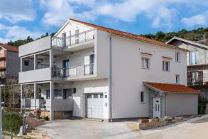 un edificio de apartamentos blanco con garaje en Apartments Tanya en Šibenik