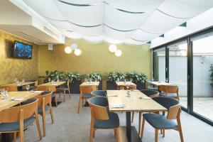 un restaurante con mesas y sillas de madera y ventanas en Fine Restaurant & Apartments, en Malacky