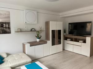 a living room with white cabinets and a television at Belvárosi Luxus Apartman in Baja