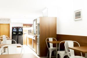 a kitchen with a table and chairs and a refrigerator at Sweet Hotel Continental in Valencia