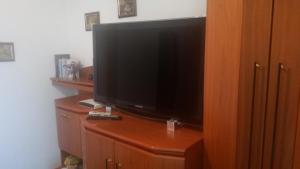 Elle comprend une télévision à écran plat installée au-dessus d'un meuble en bois. dans l'établissement Haus Sandra, à Ahlbeck