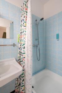 a bathroom with a shower curtain next to a sink at Ferienwohnung Hochgefühl in Hohegeiß