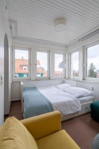 a bedroom with a large bed and two windows at Ferienwohnung Hochgefühl in Hohegeiß