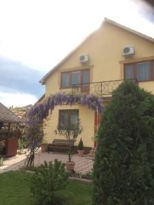 una casa con una corona de flores púrpuras. en Квітковий двір, en Golubinoye