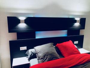 1 dormitorio con 1 cama con 2 almohadas y 2 luces en Bella vita en Thonon-les-Bains