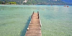 a wooden pier in the middle of a body of water at L'appartement d'Anna in Annecy