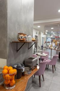 a restaurant with a counter with oranges on it at Pan Hotel in Athens