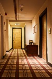 a hallway with a door and a tiled floor at Hotel Europa in Cortina dʼAmpezzo