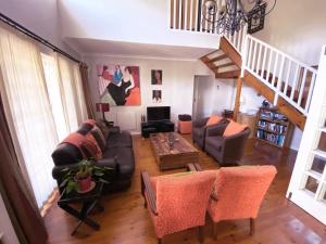 a living room with a couch and a table at Jonquil Guest Cottage in Franschhoek