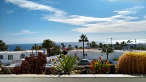 vistas a un aparcamiento con palmeras y edificios en Vv Apartamento Gran Vista Los Marinos, en Tías