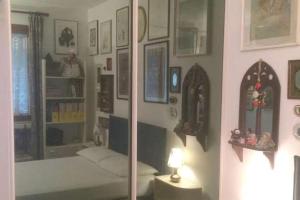 a room with a bedroom with a bed and a mirror at Appartamento dei Salici in Lazise