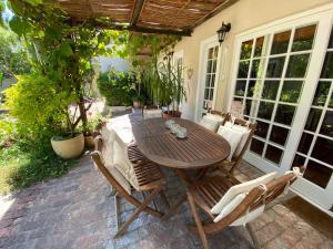 Jonquil Guest Cottage في فرانستشوك: طاولة وكراسي خشبية على الفناء