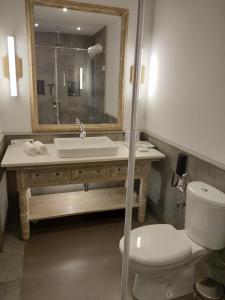 uma casa de banho com um lavatório, um WC e um espelho. em Andores Resort And Spa - Calangute em Calangute