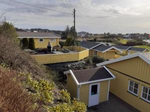 Skudenes Camping في Skudeneshavn: صف من البيوت الصفراء في بلدة