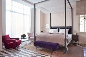 1 dormitorio con cama con dosel y silla roja en Bagatelle Gardenhouse, en Budapest