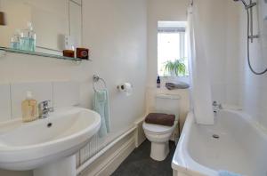 a bathroom with a sink and a toilet and a tub at Bridge House By Treetop Property in Cirencester +7 photos